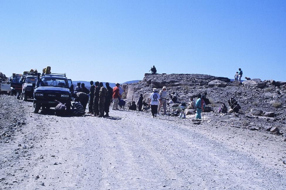 L'expertise du véhicule accidenté est en cours ; un soldat en armes fait le guet