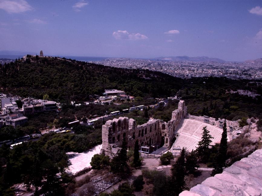 Vue sur l'odéon d'Hérode Atticus ; au loin, la ville moderne d'Athènes